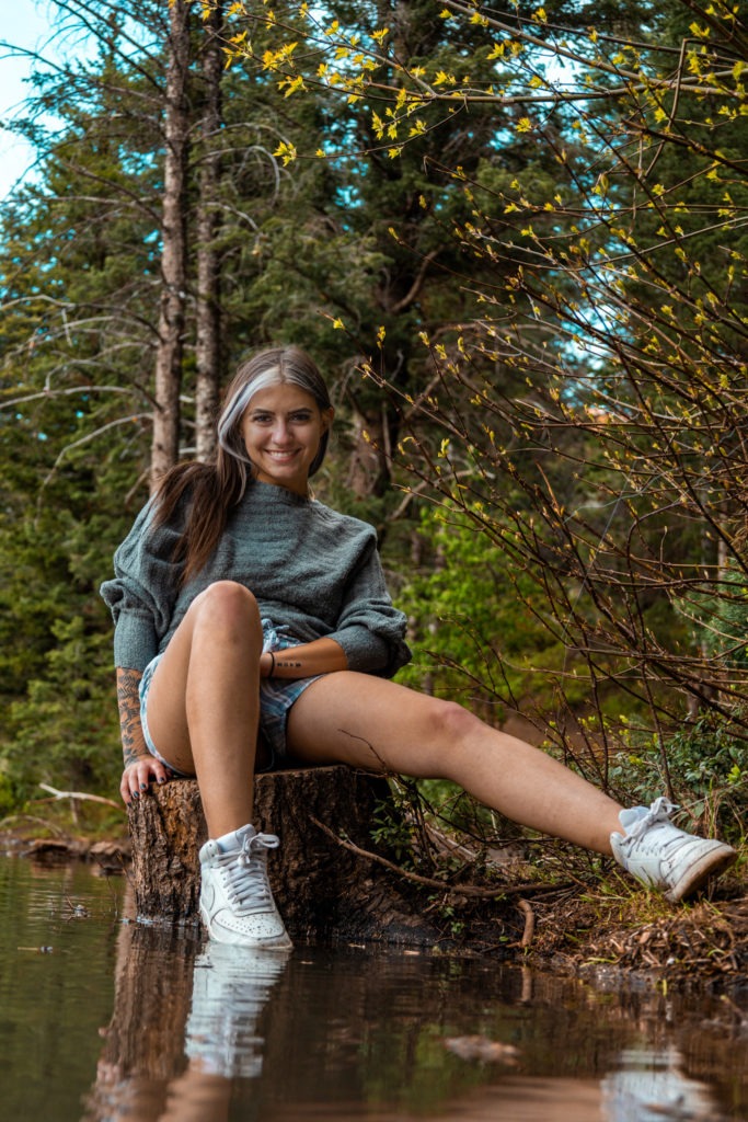 brown haired girl sitting on a log for Hartford Photography senior picture 