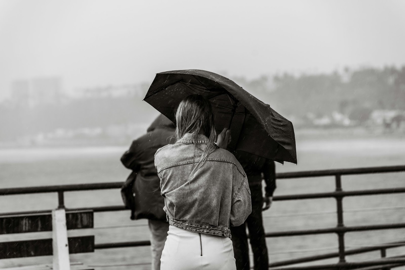 rainy day photograph of women holding umbrella 